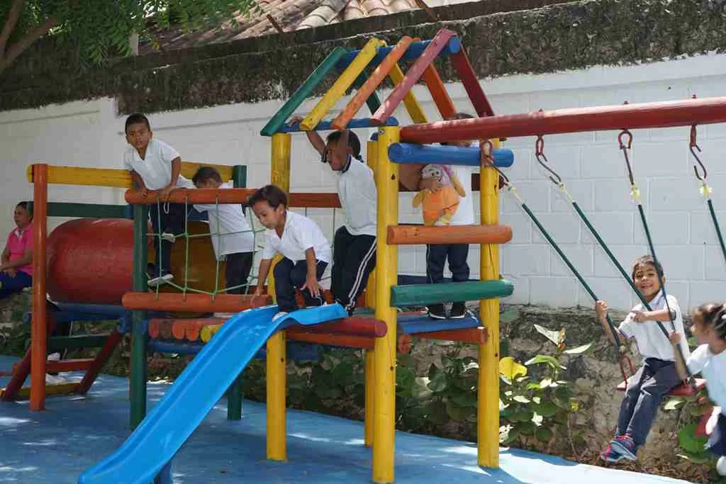 Niños jugando en el módulo de escalada y columpios