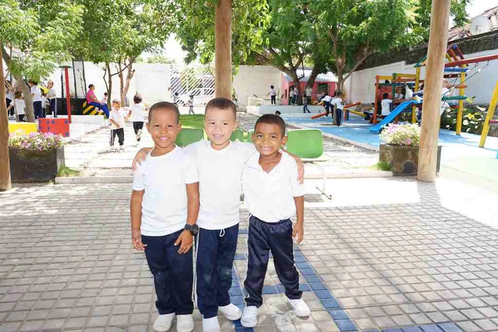 Tres niños sonriendo abrazados